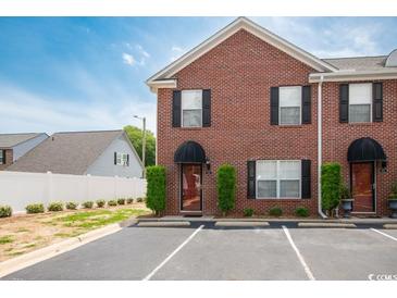 Charming brick townhome with black shutters and manicured landscaping, offering great curb appeal at 404 1St Ave. N # H, North Myrtle Beach, SC 29582