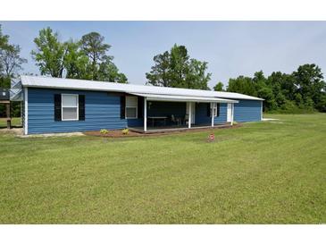 Charming single-story home with blue siding, white trim and a welcoming covered front porch at 445 W Willow Pond Rd., Johnsonville, SC 29555