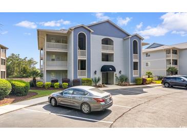 Inviting condo complex featuring manicured landscaping, classic architecture, and convenient parking spaces at 4520 Coquina Harbour Dr. # F-3, Little River, SC 29566