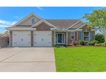 Charming brick home with a well-manicured lawn, two-car garage, and inviting front entrance at 5 Coffee Mill Creek Ln., Carolina Shores, NC 28467