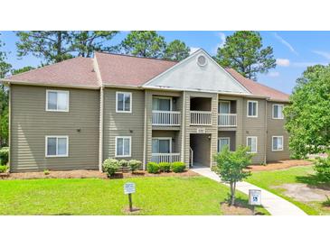 Attractive condo building with balconies, green lawn and mature trees at 500 Myrtle Greens Dr. # D, Conway, SC 29526