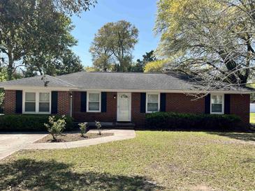Charming red brick home with a well-maintained lawn and classic black shutters at 505 1St Ave. S, North Myrtle Beach, SC 29582