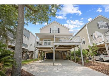 Inviting beach house on stilts featuring a spacious covered deck and ground-level parking at 108 N Oak Dr., Surfside Beach, SC 29575