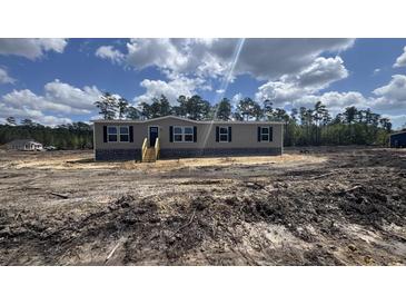 New construction, single-story home featuring horizontal siding, black shutters, and a wooden front porch at 1300 Rabbit Ln., Conway, SC 29526