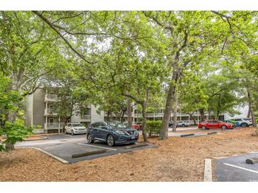 Exterior of the home in a parking lot with mature trees in a quiet community at 415 Ocean Creek Dr. # 2330, Myrtle Beach, SC 29572