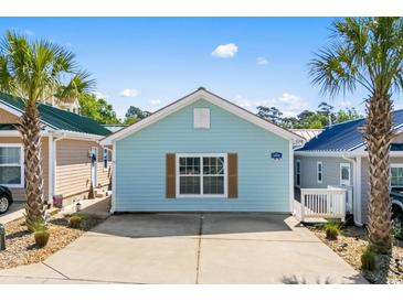 Charming single-story home with light blue siding, brown shutters, and a concrete driveway at 4338 Grande Harbour Blvd., Little River, SC 29566
