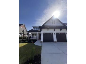 Stunning two-story home featuring a three-car garage, landscaped yard, and charming front porch at 5009 Middleton Dr., Myrtle Beach, SC 29579