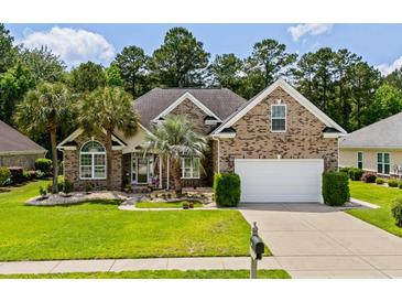 Charming brick home featuring a manicured lawn, palm trees, and a two-car garage at 950 Henry James Dr., Myrtle Beach, SC 29579