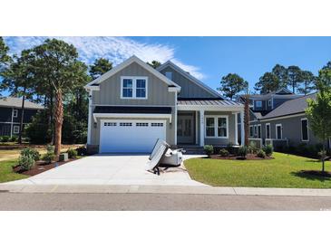 Inviting two-story home with a lush green lawn and attached two-car garage at 1424 Hydrangea Dr., Myrtle Beach, SC 29579