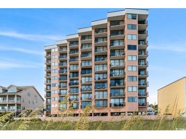 Multi-story condo building featuring private balconies, offering stunning views of the surrounding landscape and blue sky at 1501 Ocean Blvd. S # 103, North Myrtle Beach, SC 29582