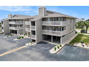 Three-story condo building showcases covered parking, multiple decks, neutral color palette, and well-maintained landscaping at 1801 N Ocean Blvd. # Q-2, North Myrtle Beach, SC 29582