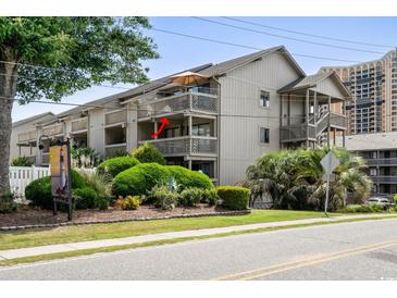 Exterior view of a condo with multiple balconies, showcasing lush landscaping and mature trees at 202 Maison Dr. # L-301, Myrtle Beach, SC 29572