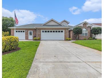 Well-maintained brick home featuring a three-car garage, a lush green lawn, and a welcoming entrance at 2479 Glen Dr., Little River, SC 29566