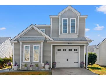 Charming gray two-story home featuring a white garage door and beautifully landscaped front yard at 314 Lyons Cove Dr., Myrtle Beach, SC 29577