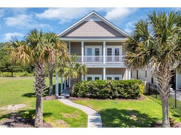 Charming two-story home with double porches and lush landscaping featuring mature palm trees at 338 St. Julian Ln., Myrtle Beach, SC 29579