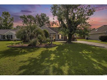 Charming home with lush front yard, mature trees, well-maintained lawn, and inviting landscaping at 3910 Stillwood Dr., Myrtle Beach, SC 29588