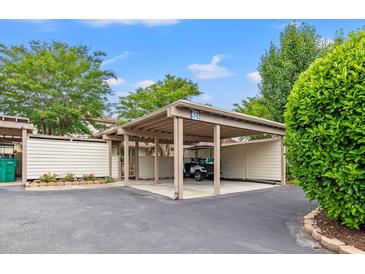 A covered carport provides parking and shelter for a golf cart, offering convenient protection from the elements at 430 Ocean Creek Dr. # 2534, Myrtle Beach, SC 29572