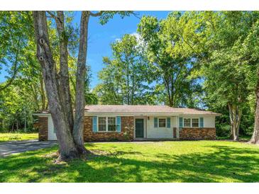 Charming one-story home featuring a brick and white facade with blue shutters and a well-maintained lawn at 4300 Crows Nest Ct., Myrtle Beach, SC 29579