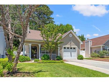 Charming one-story home with well-manicured lawn, attached garage, and a welcoming front porch at 4406 Barcelona Ln., Little River, SC 29566