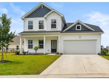 Charming two-story home with a well-manicured lawn, attached garage, and a welcoming front porch at 863 Agostino Dr., Myrtle Beach, SC 29579