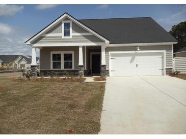 Charming single-story home with stone accents, gray siding, an attached two-car garage, and well-manicured lawn at 8715 Baton Rouge Ave Nw, Calabash, NC 28467