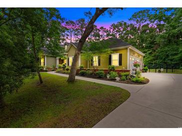 Charming one-story home with manicured landscaping, walkway, driveway, and attached garage surrounded by mature trees at 116 Chapel Ridge Circle, Myrtle Beach, SC 29588