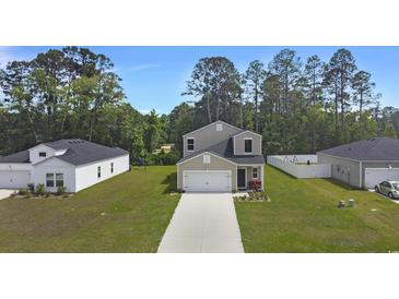 Charming two-story home featuring a well-manicured lawn and a concrete driveway leading to an attached garage at 120 Carolina Lakes Blvd., Myrtle Beach, SC 29588