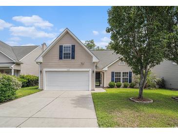 Charming home featuring a two-car garage, well-kept lawn, and mature tree providing ample shade at 140 Avondale Dr., Myrtle Beach, SC 29588