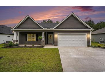 Charming single-story home with well-maintained lawn, gray siding, and a two-car garage at sunset at 1476 Burriss Rd., Conway, SC 29526
