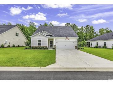 Charming single-story home with a well-manicured lawn and attached two-car garage at 191 Marley Blue Dr., Little River, SC 29566
