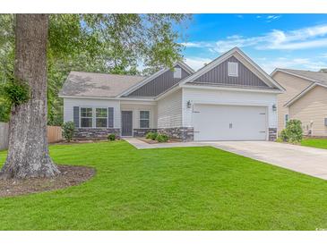 Charming one-story home with well-manicured lawn and a two-car garage on a sunny day at 3539 Harrelson Ave., Loris, SC 29569