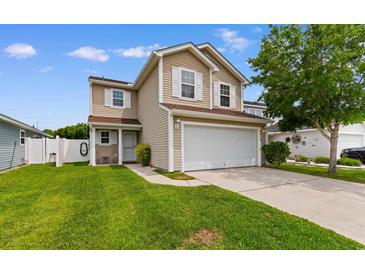 Charming two-story home featuring a spacious front yard, two-car garage, and neutral siding, all under a sunny sky at 4013 Blackwolf Dr., Myrtle Beach, SC 29579