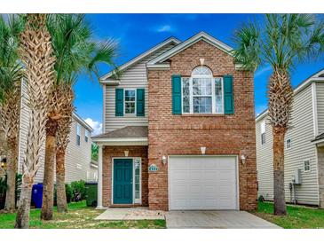 Charming two-story home with brick facade, teal accents, an attached garage and mature palm trees at 422 South Poplar Dr., Surfside Beach, SC 29575