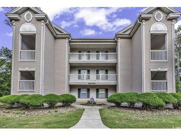 Three-story condo complex with beautiful balconies, green shutters and well-maintained landscaping at 598 Blue Stem Dr. # 52E, Pawleys Island, SC 29585