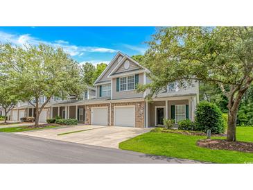 Inviting townhome with a two-car garage, green shutters and a manicured lawn at 751 Painted Bunting Dr. # E, Murrells Inlet, SC 29576