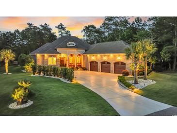 Elegant brick home featuring a three-car garage, manicured lawn, and inviting curb appeal at dusk at 81 Cascade Dr., Murrells Inlet, SC 29576