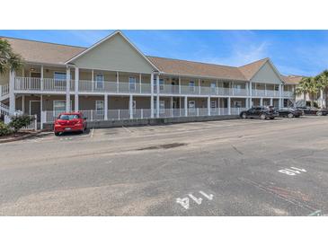 This is an exterior view of the condo building with a parking lot in front of it at 117 Butkus Dr. # 6, Myrtle Beach, SC 29588