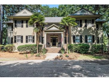 Charming home featuring brick entrance, lush landscaping, and inviting front porch at 159-1 Weehawka Way # 159-1, Pawleys Island, SC 29585
