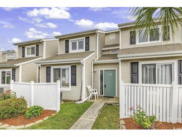 Inviting townhome with a well-manicured lawn and a charming white picket fence under a bright sky at 1600 Deer Creek Rd. # F, Myrtle Beach, SC 29575