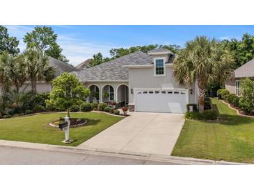 Beautiful home featuring a meticulously landscaped front yard, a two-car garage, and elegant architectural details at 2318 Via Palma Dr., North Myrtle Beach, SC 29582