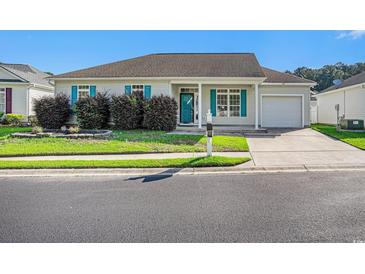 Charming single-story home with blue shutters, well-manicured landscaping, and an attached garage at 264 La Patos Dr., Myrtle Beach, SC 29588