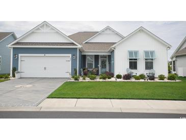 Charming single-Gathering home featuring a two-car garage, lovely landscaping, and a welcoming front porch at 383 Mikita Dr., Surfside Beach, SC 29575