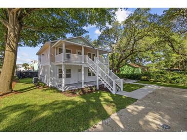 Charming two-story home with a spacious front yard, inviting staircase, and lovely curb appeal at 409 2Nd Ave. S, Myrtle Beach, SC 29577