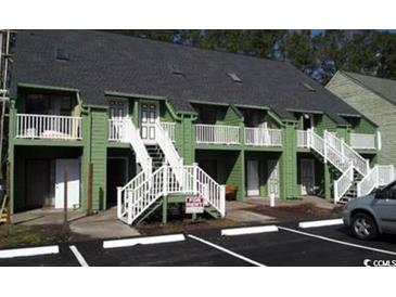 Exterior view of two-story condominium with green siding, white railings, and stairs to second-floor entrances at 411 Cambridge Circle # D4, Murrells Inlet, SC 29576