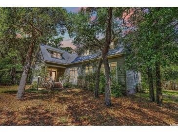 Charming two-story home nestled among trees with a metal roof and inviting front porch at 4131 Gunter Lake Rd., Galivants Ferry, SC 29544