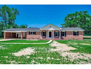 Charming brick home featuring classic black shutters, white trim, and a convenient attached carport at 4145 Highway 308, Galivants Ferry, SC 29544