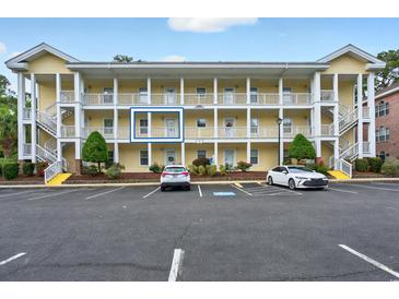 Attractive multi-story condo building with ample parking spaces and well-kept landscaping and inviting stairwells at 4251 Hibiscus Dr. # 202, Little River, SC 29566