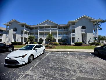 Condo building with white trim, balconies, landscaping and parking at 4430 Eastport Blvd. # L-11, Little River, SC 29566