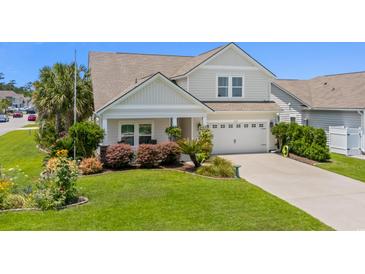Charming two-story home featuring a well-manicured lawn and an attached two-car garage at 450 Oaklanding Ln., Murrells Inlet, SC 29576