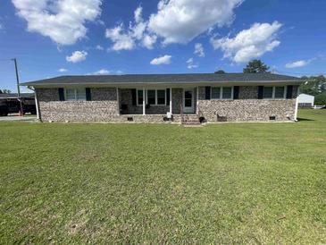 Charming brick ranch home with a well-manicured lawn and inviting curb appeal on a sunny day at 4637 Dogwood St., Loris, SC 29569